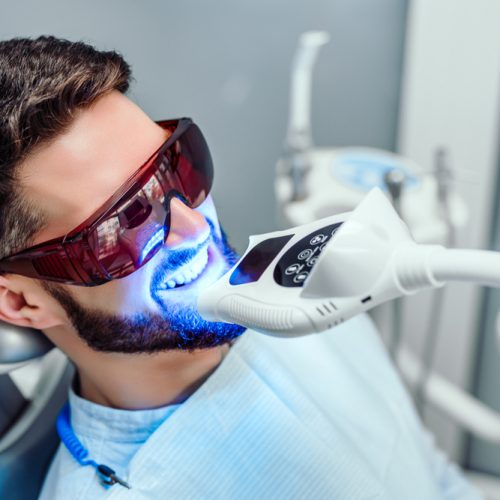 man receiving teeth whitening at dental office